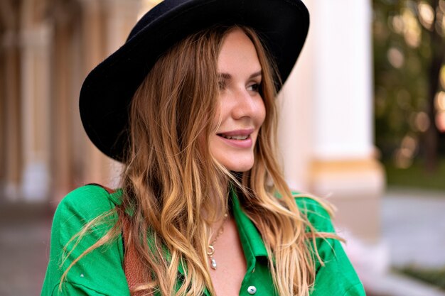 Primer plano sensual retrato de mujer rubia elegante con maquillaje natural de pelos rizados y cara bonita, con sombrero negro