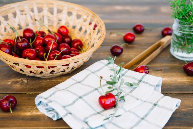 Primer plano de la servilleta y jugosas cerezas rojas en un tazón de mimbre