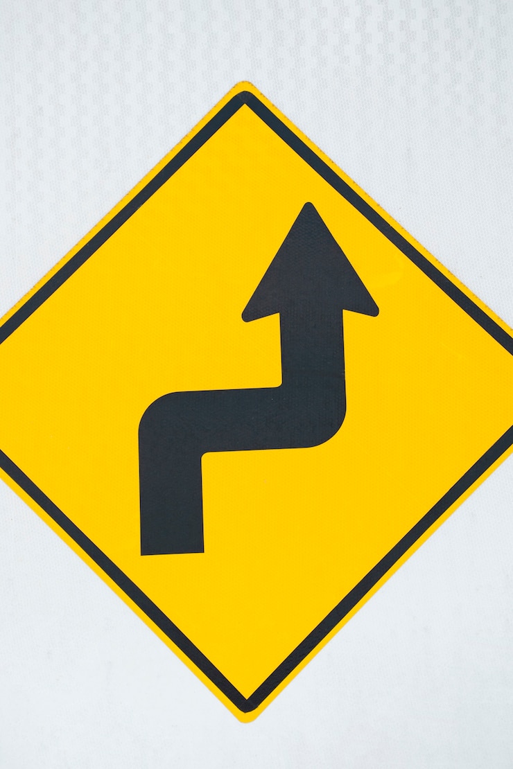 Foto gratuito primer plano de signo de flecha de carretera de doble curva