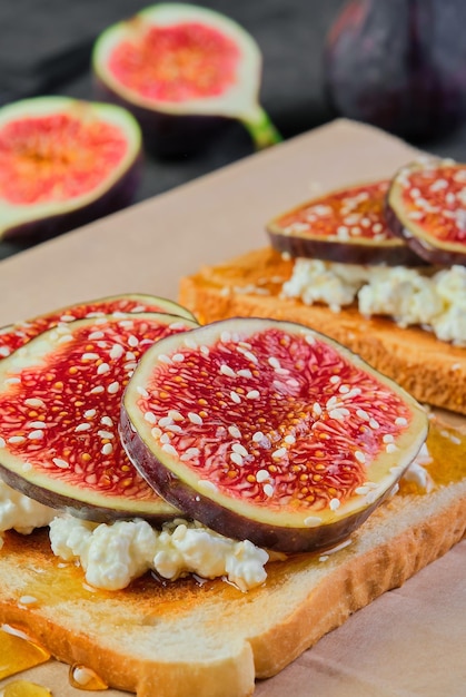 Primer plano sobre tostadas con miel de higos y queso ricotta espolvoreado con marco vertical de semillas de sésamo Enfoque selectivo en la idea de desayuno sándwich o foto para el menú desayuno mediterráneo