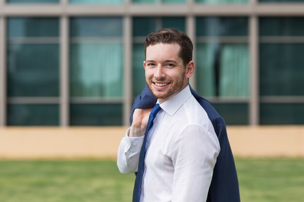 Primer plano, sonriente, hombre de negocios, posición, afuera