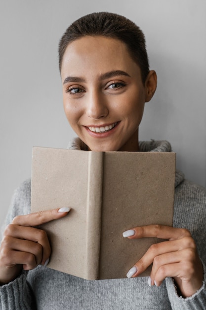 Foto gratuita primer plano, sonriente, mujer, tenencia, cuaderno