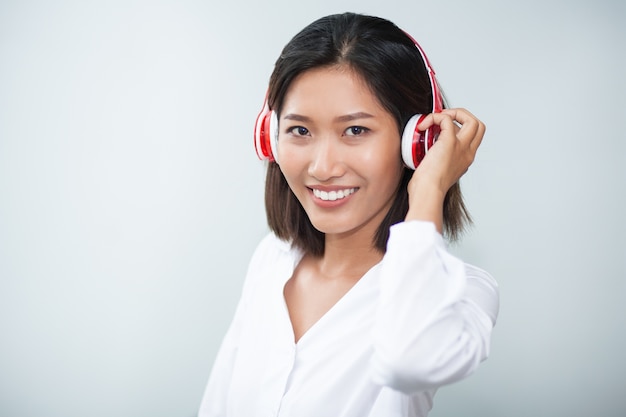 Primer plano de la sonrisa mujer bonita que lleva los auriculares