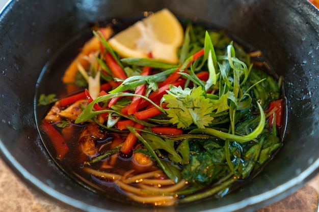 Foto gratuita primer plano de sopa con verduras, limón y verduras en una placa negra