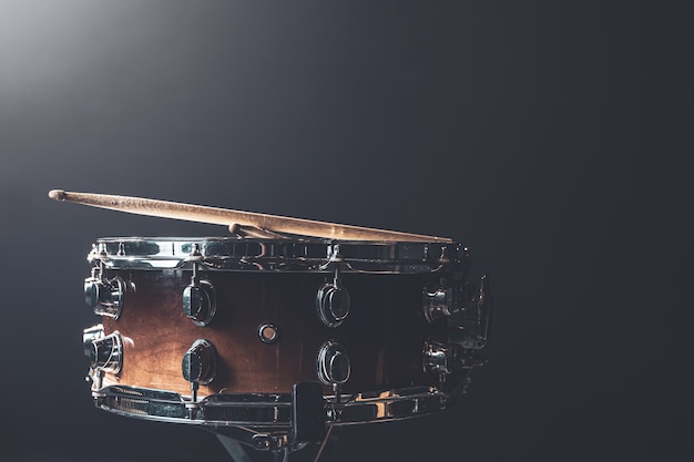 Primer plano, tambor, instrumento de percusión contra un fondo oscuro con  iluminación de escenario, espacio de copia. | Foto Gratis