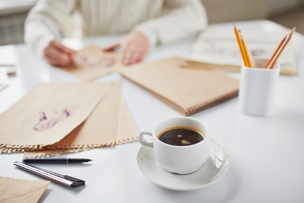 Primer plano de la taza de café con bocetos