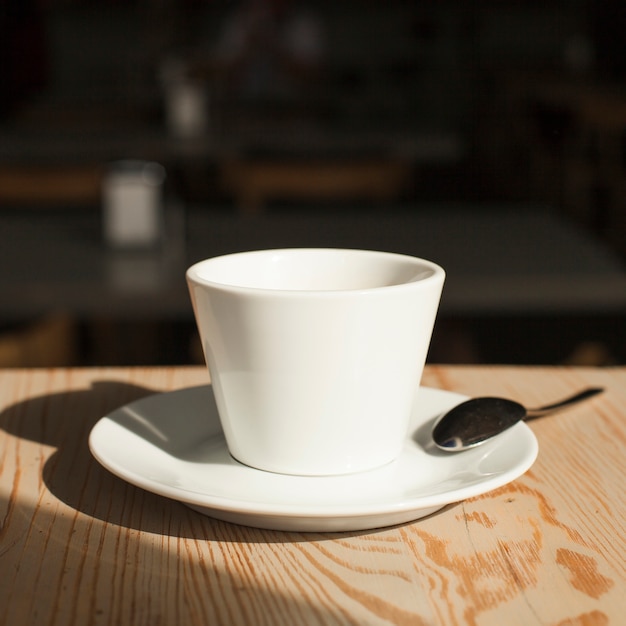 Primer plano de la taza de café y una cuchara en el escritorio