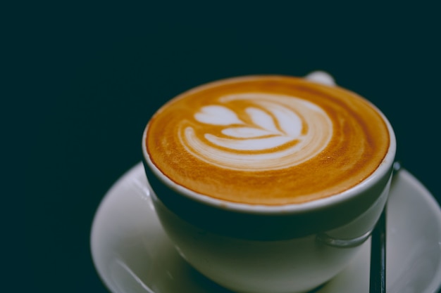 Primer plano de una taza de delicioso café con leche en un platillo