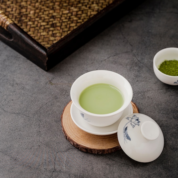 Primer plano de la taza de té matcha en posavasos y bandeja