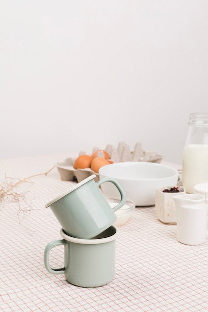 Primer plano de tazas de té delante de ingredientes orgánicos sobre mesa