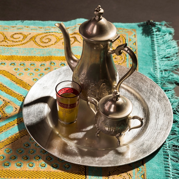 Primer plano de té caliente árabe tradicional en la alfombra de oración
