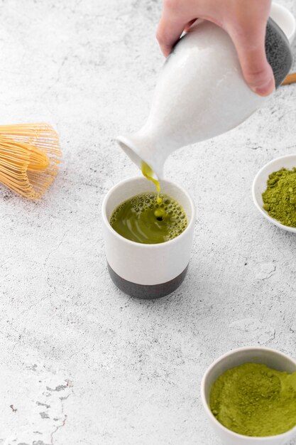 Primer plano de té matcha vertiendo en taza