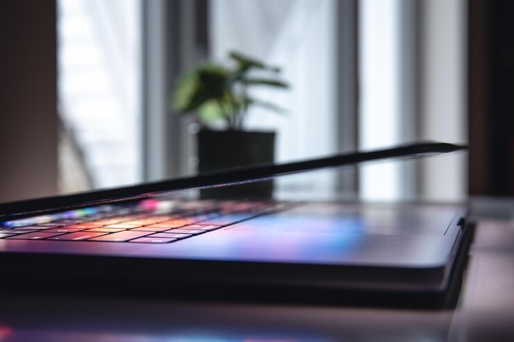 Foto gratuito un primer plano del teclado de la computadora portátil con iluminación de neón de colores y teclado retroiluminado