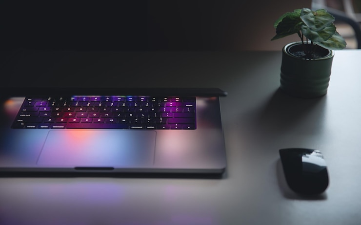 Foto gratuito un primer plano del teclado de la computadora portátil con iluminación de neón de colores y teclado retroiluminado