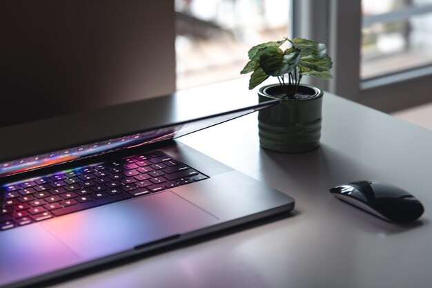 Primer plano del teclado del portátil con iluminación de neón colorida y teclado retroiluminado