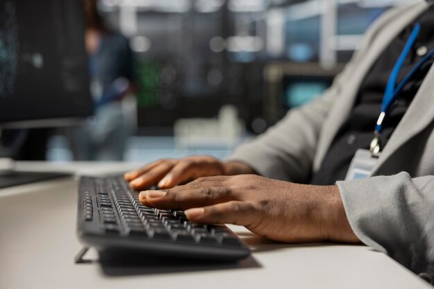 Primer plano de un técnico del centro de datos escribiendo en el teclado inspeccionando el equipo