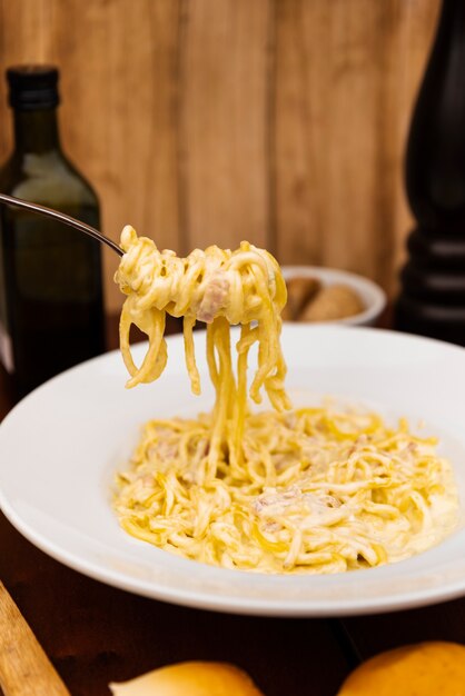 Primer plano de tenedor con deliciosa pasta de espagueti con queso