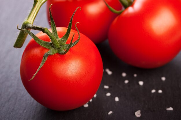 Primer plano de tomate perfecto sobre mesa negra
