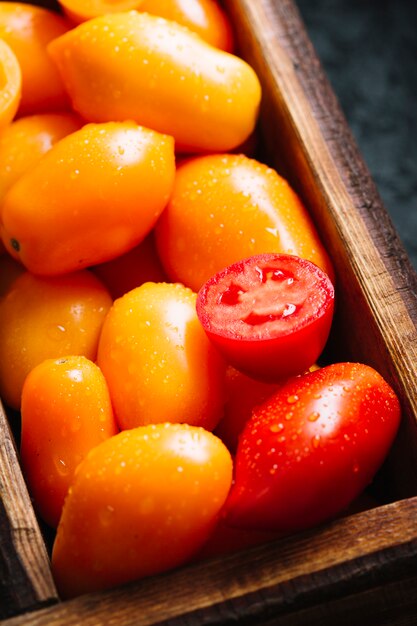 Primer plano de tomates pequeños naranjas y rojos