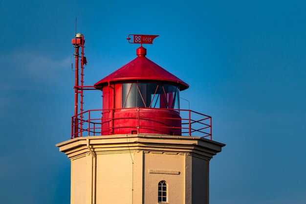 Primer plano de una torre roja y blanca detrás de un cielo azul