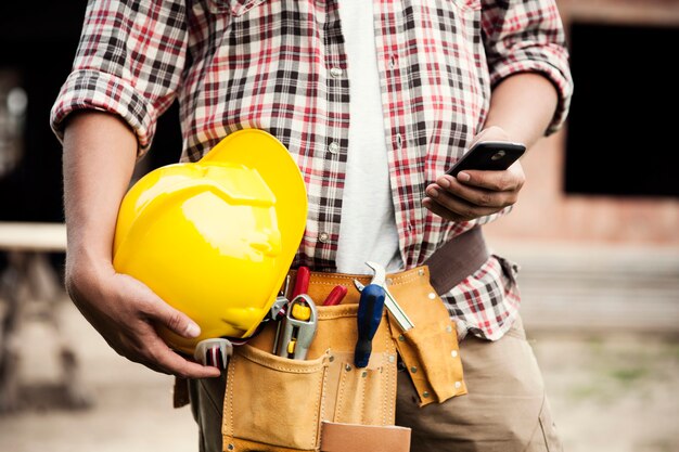 Primer plano, de, trabajador de la construcción, mensajes de texto, en, teléfono móvil