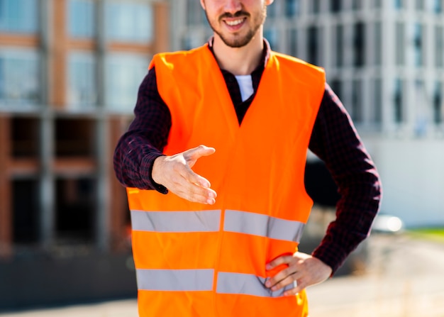 Foto gratuita primer plano trabajador de la construcción que ofrece apretón de manos