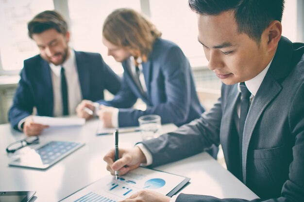 Primer plano de trabajador escribiendo en el informe