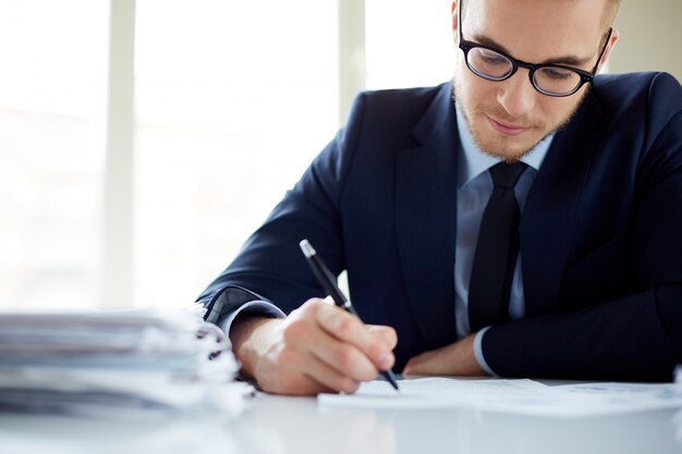 Primer plano de trabajador escribiendo un informe