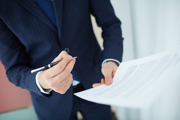 Foto gratuita primer plano trabajador leyendo el contrato antes de firmar