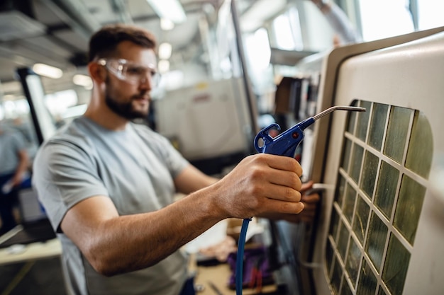 Primer plano de un trabajador que opera una máquina industrial en una fábrica