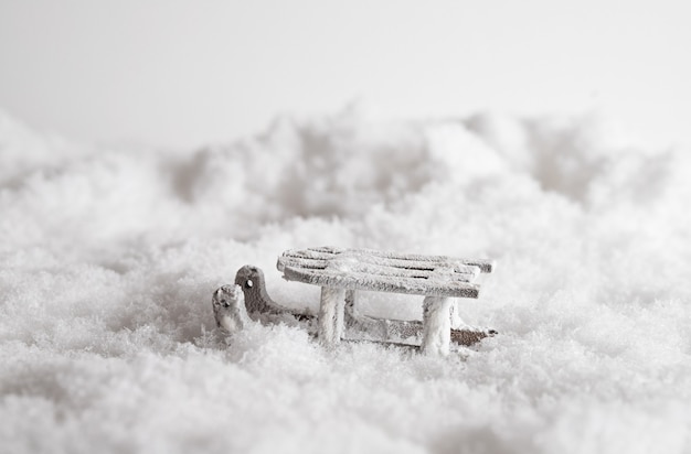 Foto gratuita primer plano de un trineo en la nieve, juguetes decorativos de navidad en el fondo blanco.