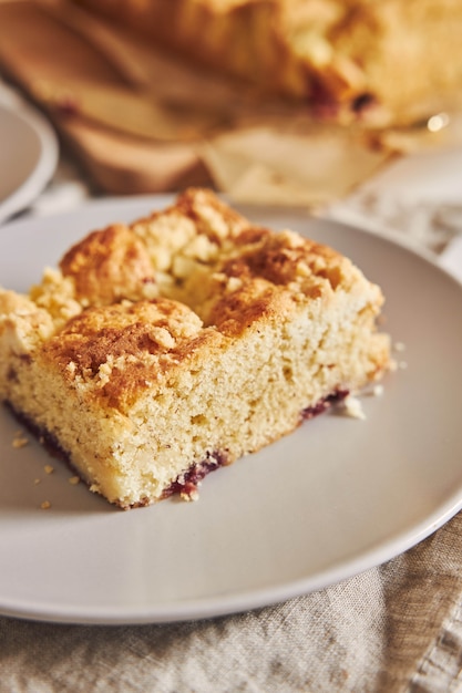 Primer plano de un trozo de delicioso Jerry Crumble Sheet cake sobre mesa de madera blanca