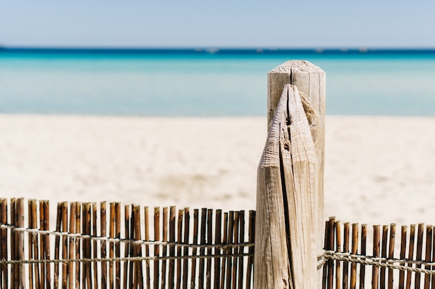 Primer plano de valla de madera en la playa