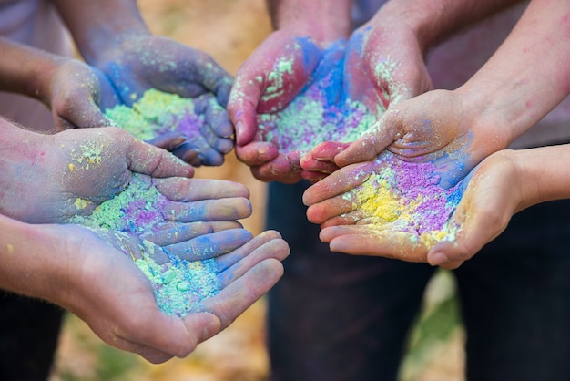 Primer plano de varias manos con color en polvo