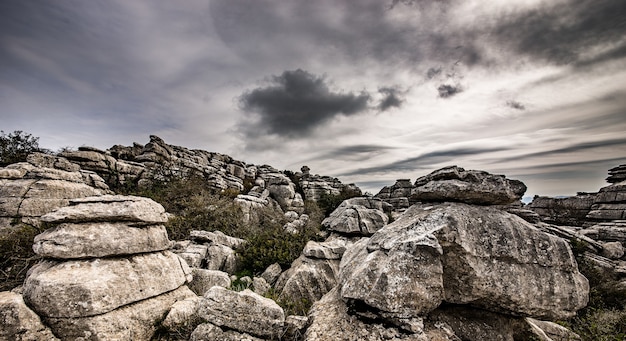 Primer plano de varias rocas grises una encima de la otra bajo un cielo nublado