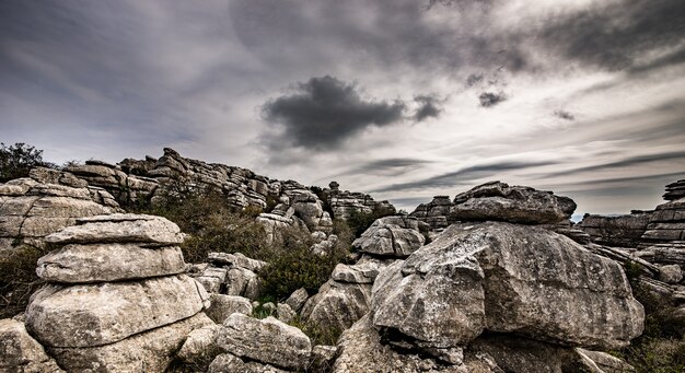 Primer plano de varias rocas grises una encima de la otra bajo un cielo nublado