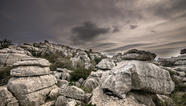 Primer plano de varias rocas grises una encima de la otra bajo un cielo nublado