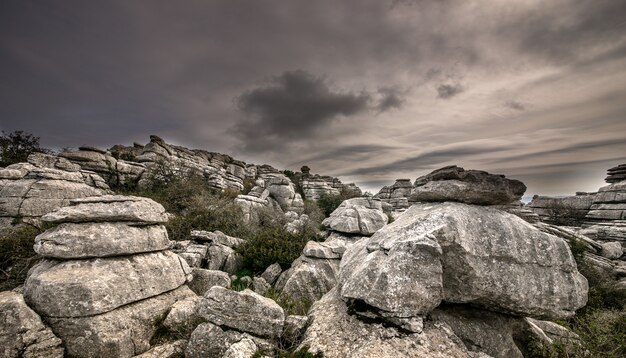 Primer plano de varias rocas grises una encima de la otra bajo un cielo nublado