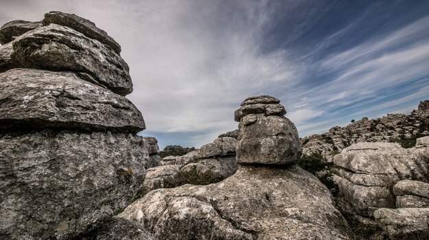 Primer plano de varias rocas grises una encima de la otra bajo un cielo nublado