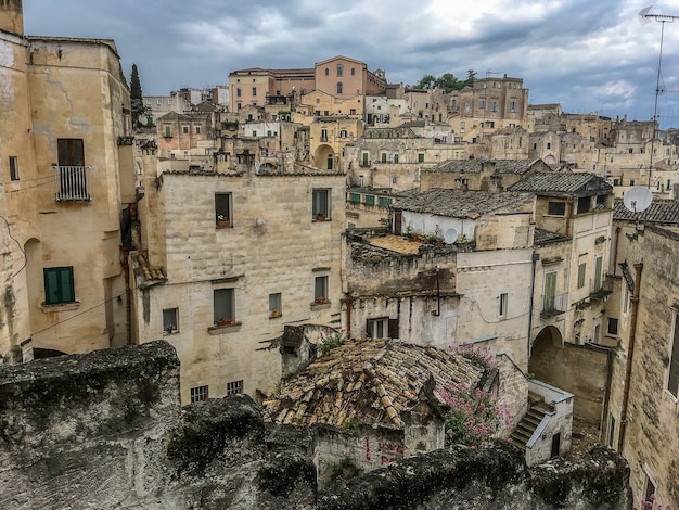 Primer plano de varios edificios antiguos construidos uno al lado del otro bajo un cielo lleno de nubes