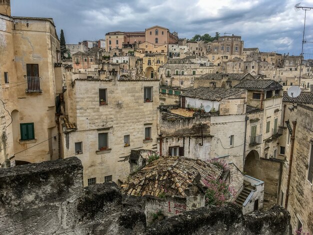 Primer plano de varios edificios antiguos construidos uno al lado del otro bajo un cielo lleno de nubes