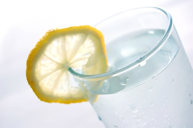 Primer plano de vaso de agua con una rodaja de limón