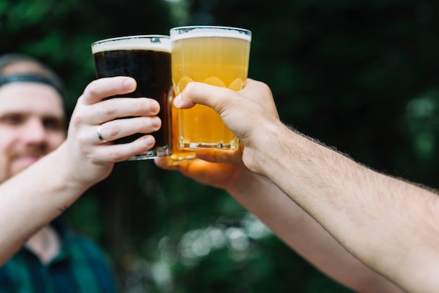 Primer plano de un vaso de bebidas alcohólicas de la mano de un amigo