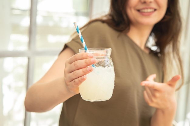 Primer plano un vaso de limonada en manos femeninas