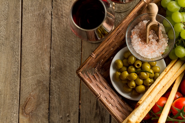 Primer plano de vasos de vino junto a una cesta de mimbre con productos