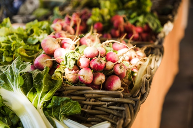 Primer plano de vegetales en canasta de mimbre en el mercado de vegetales