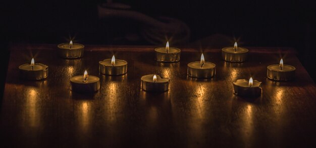 Primer plano de velas encendidas en una mesa de madera