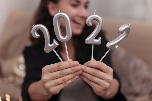 Foto gratuita primer plano de velas en forma de números 2022 en manos femeninas.