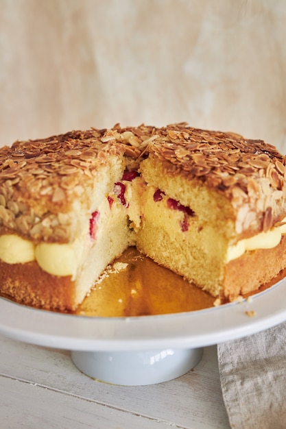 Primer plano vertical de la deliciosa tarta de crema de vainilla con fresas dentro de una mesa blanca