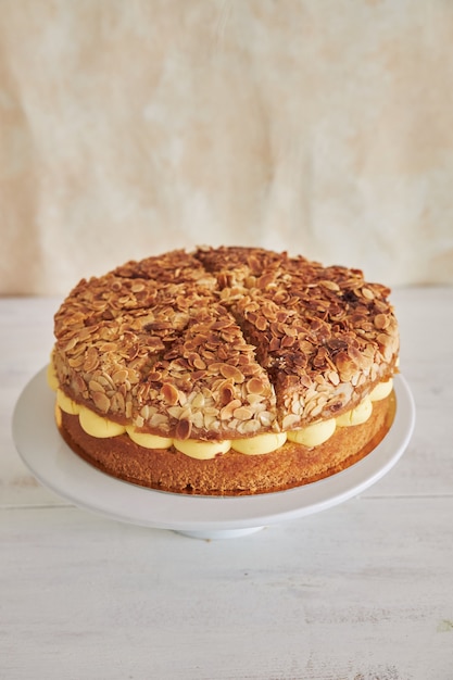 Primer plano vertical de la deliciosa tarta de crema de vainilla con fresas dentro de una mesa blanca